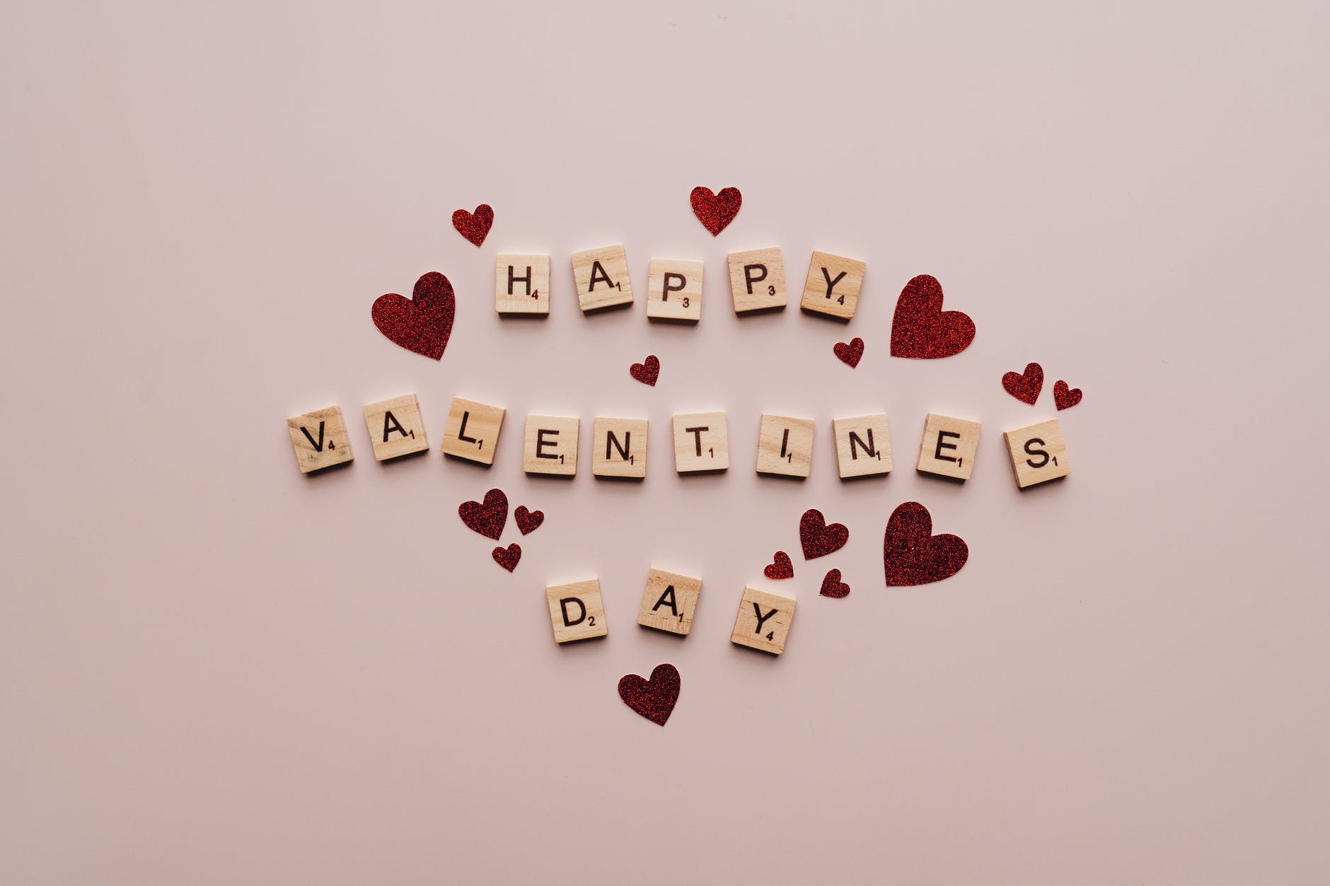 happy valentine s day text on pink surface